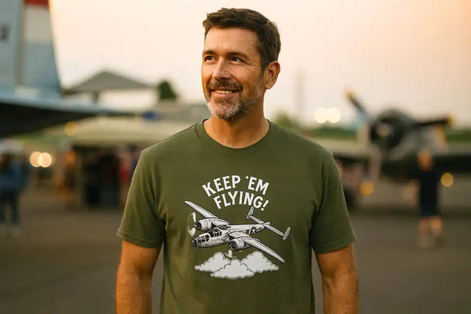 A man wearing an olive green t-shirt with a vintage aircraft graphic.